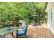 Outdoor deck features a stainless steel grill, dining table and chairs, and vibrant foliage for relaxing and entertaining at 218 Woodruff Way, Peachtree City, GA 30269