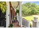 Inviting covered porch with brick flooring, classic columns, and a cozy rocking chair overlooking a lush lawn at 218 Woodruff Way, Peachtree City, GA 30269