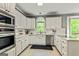 Bright kitchen featuring white cabinetry, stainless steel appliances, and quartz countertops at 218 Woodruff Way, Peachtree City, GA 30269