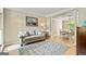 Bright living room with hardwood floors, a neutral sofa, and a dining area beyond, ideal for gatherings at 218 Woodruff Way, Peachtree City, GA 30269