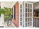 Front porch of a brick home featuring a rocking chair, exterior wall and open doors to entry at 218 Woodruff Way, Peachtree City, GA 30269