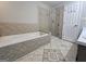 Bathroom featuring a tiled tub-shower combination with glass doors and neutral patterned flooring at 105 Old Hickory Pointe, Mcdonough, GA 30252