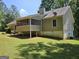 Back exterior view of house showing screened in porch area in a well-maintained backyard at 105 Old Hickory Pointe, Mcdonough, GA 30252