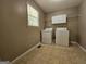 Functional laundry room featuring washer, dryer, and practical storage, illuminated by natural light from the window at 105 Old Hickory Pointe, Mcdonough, GA 30252