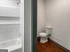 Bathroom featuring a tiled shower with a built-in shelf and a toilet at 1128 Milstead Ne Ave, Conyers, GA 30012