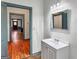 Bathroom with a vanity, a large mirror, hardwood floors, and doorways to adjoining rooms at 1128 Milstead Ne Ave, Conyers, GA 30012