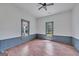 Bright bedroom with wood floors, large windows offering natural light, and a modern ceiling fan at 1128 Milstead Ne Ave, Conyers, GA 30012