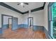 Open bedroom layout featuring wood floors, modern ceiling fan, neutral paint, and natural light at 1128 Milstead Ne Ave, Conyers, GA 30012