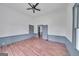 Spacious bedroom with wood floors, fresh paint, updated ceiling fan, and multiple doors at 1128 Milstead Ne Ave, Conyers, GA 30012