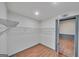 Walk-in closet space features a wire shelving system and access to another room in neutral color palette at 1128 Milstead Ne Ave, Conyers, GA 30012