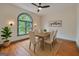 Bright dining room featuring a rustic table set, large arched window, and a 'gather' sign for a cozy atmosphere at 1128 Milstead Ne Ave, Conyers, GA 30012