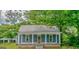 Single-story home showcasing a quaint porch with sturdy columns and a durable metal roof at 1128 Milstead Ne Ave, Conyers, GA 30012