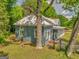 Exterior view of the home highlighting the well-maintained lawn, mature trees, and back facade at 1128 Milstead Ne Ave, Conyers, GA 30012