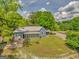 Exterior home view with large front yard, mature trees, a screened-in porch, and long driveway at 1128 Milstead Ne Ave, Conyers, GA 30012