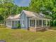 Exterior of house showcasing a covered porch, screened-in porch, manicured lawn, and beautiful curb appeal at 1128 Milstead Ne Ave, Conyers, GA 30012
