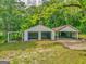 Detached garage with multiple bays offers ample parking and storage space on a spacious lot surrounded by trees at 1128 Milstead Ne Ave, Conyers, GA 30012