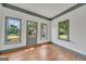 Bright living room featuring three large windows allowing ample natural light, and hardwood floors at 1128 Milstead Ne Ave, Conyers, GA 30012