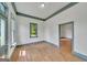 Bright living room showcasing hardwood floors and natural light from two windows and a doorway at 1128 Milstead Ne Ave, Conyers, GA 30012