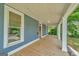 Long front porch with white columns and wooden floor offer plenty of space for relaxing and entertaining at 1128 Milstead Ne Ave, Conyers, GA 30012