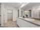 Well-lit bathroom featuring a double sink vanity, an open doorway, and a shower with glass doors at 560 Whitman Ln # 2016, Stockbridge, GA 30281
