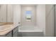 Well-lit bathroom with a soaking tub, window, and modern fixtures and a glass shower at 560 Whitman Ln # 2016, Stockbridge, GA 30281