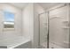 Bathroom featuring a soaking tub and a glass-enclosed shower, plus a window with a view at 560 Whitman Ln # 2016, Stockbridge, GA 30281