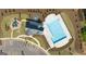 Aerial view of community pool and playground, surrounded by lush landscaping and a parking lot at 560 Whitman Ln # 2016, Stockbridge, GA 30281