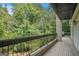Spacious outdoor balcony with wood flooring offering serene views of lush trees and greenery at 3192 Paces Mill Se Rd, Atlanta, GA 30339