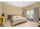 Bright bedroom featuring a large bed with stylish gray and yellow bedding and an upholstered storage bench at 3192 Paces Mill Se Rd, Atlanta, GA 30339