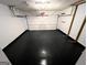 Spacious garage with epoxy flooring and an automatic garage door, offering secure parking and ample storage space at 3838 Kirkwood Nw Run, Kennesaw, GA 30144