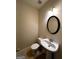 Small powder room with a round mirror over a pedestal sink and a toilet at 3838 Kirkwood Nw Run, Kennesaw, GA 30144