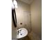 Cozy powder room featuring a pedestal sink with an oval mirror and a paneled door at 3838 Kirkwood Nw Run, Kennesaw, GA 30144