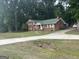 Exterior view of a brick home with a long concrete driveway and ample green space at 603 New Hope Rd, Fayetteville, GA 30214