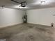 Open garage with cement floor, fire extinguisher, and hot water heater at 6190 Douglas Manor Ct, Douglasville, GA 30134