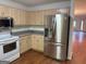 Bright kitchen featuring stainless steel refrigerator, wood cabinets, and modern appliances at 6190 Douglas Manor Ct, Douglasville, GA 30134