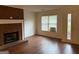 Cozy living room showcasing a brick fireplace, hardwood floors, and bright window view at 6190 Douglas Manor Ct, Douglasville, GA 30134