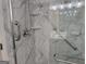 Updated marble shower featuring grab bars and built-in shelving at 6190 Douglas Manor Ct, Douglasville, GA 30134