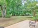 Expansive backyard features mature trees, lush grass, and a cozy patio seating area at 1585 Lake Dow Rd, Mcdonough, GA 30252