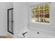 Clean bathroom featuring a black framed glass shower door, a garden tub, and natural light at 1585 Lake Dow Rd, Mcdonough, GA 30252
