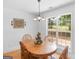 Cozy dining area with wood table, four chairs, light fixture and a view to outside greenery at 1585 Lake Dow Rd, Mcdonough, GA 30252