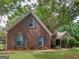 Charming brick home with well-manicured lawn, lush landscaping and mature trees providing shade at 1585 Lake Dow Rd, Mcdonough, GA 30252