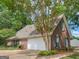 Brick home with an attached garage, and a manicured lawn with mature landscaping and inviting driveway at 1585 Lake Dow Rd, Mcdonough, GA 30252