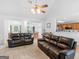 Bright living room featuring vaulted ceiling, ceiling fan, and two comfortable black leather sofas at 1585 Lake Dow Rd, Mcdonough, GA 30252