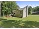 A large backyard with a wood deck and gazebo, framed by mature trees and lush green lawn at 96 Ashtonbrook Dr, Mcdonough, GA 30252