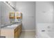 Well-lit bathroom with a light wood vanity, granite countertop, and a white tiled bathtub at 96 Ashtonbrook Dr, Mcdonough, GA 30252