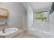 Bright bathroom featuring a bathtub, shower, large mirror, and natural light from a window at 96 Ashtonbrook Dr, Mcdonough, GA 30252