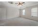 Large bedroom with a tray ceiling, fan, carpeted floors, and natural light from two windows at 96 Ashtonbrook Dr, Mcdonough, GA 30252