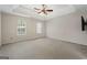 Large bedroom with a tray ceiling, fan, carpeted floors, and natural light from windows at 96 Ashtonbrook Dr, Mcdonough, GA 30252