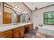 Bathroom featuring a double sink vanity, soaking tub, and tiled floors at 1627 Leguin Mill Rd, Locust Grove, GA 30248