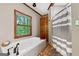 Modern bathroom showcasing a soaking tub next to a window at 1627 Leguin Mill Rd, Locust Grove, GA 30248
